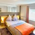 Hotel Maurer in Saarwellingen guest room with double bed, desk, and window light