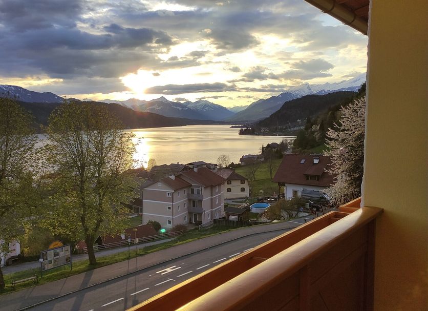 View from Pension zum Mühlrad in Millstatt of lake and mountain sunset over roadside houses.