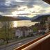 View from Pension zum Mühlrad in Millstatt of lake and mountain sunset over roadside houses.