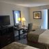 Hotel Mesa Albuquerque Midtown room with two beds, desk, TV and window curtains in Albuquerque