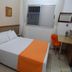 Frimas Hotel Belo Horizonte guest room with twin bed, window, desk and orange chair