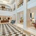 Riviera Rayhaan by Rotana Doha lobby with checkerboard floor, tall columns and red seating
