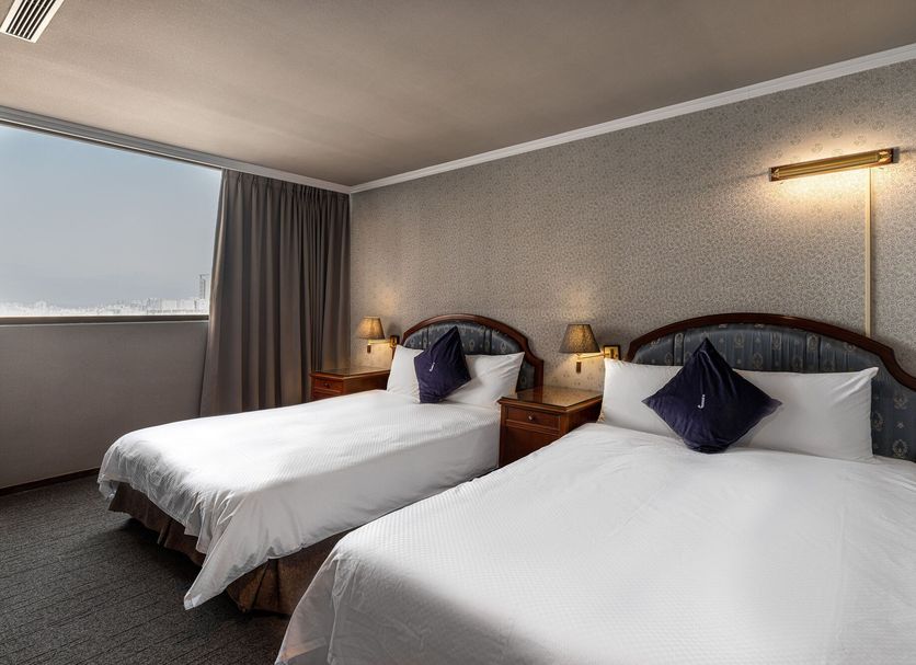 Hotel j-Metropolis in Hsinchu City guest room with two twin beds and a large window