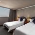 Hotel j-Metropolis in Hsinchu City guest room with two twin beds and a large window