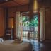 Kalm Pai in Pai room with two beds, wooden walls, and open doors to a garden view