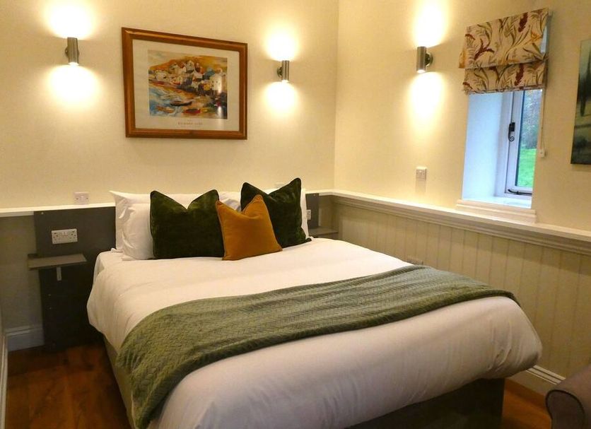 The Frocester, Stroud: cozy guest room with double bed, wall sconces, and window seat