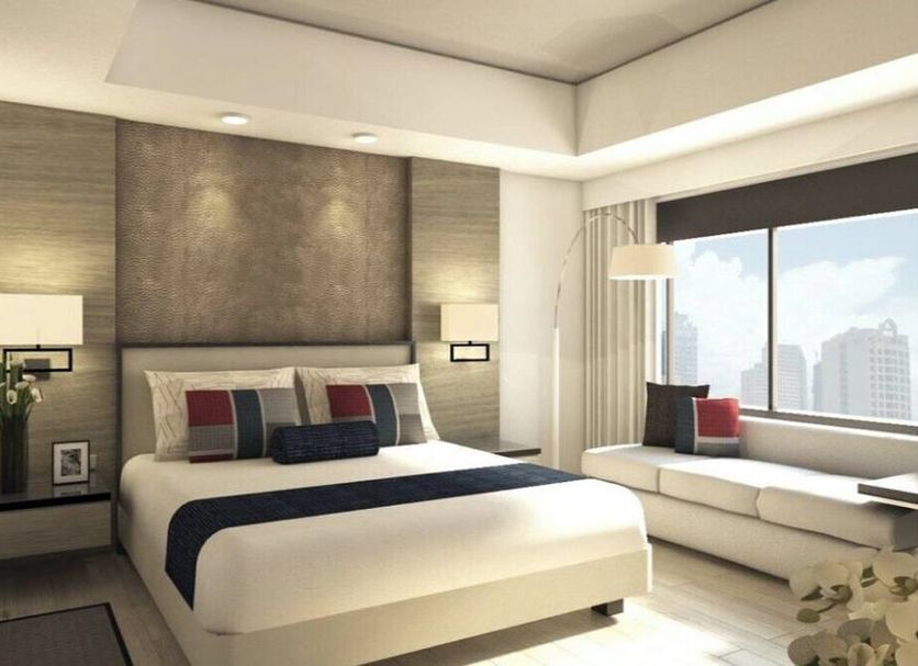 Seda Residences Makati in Manila, modern hotel room with king bed, sofa by large window and city view