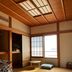 Atami Onsen Guest House Megumi in Atami: tatami room with futon, low table, and bright window view