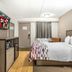 Red Roof Inn Tinton Falls-Jersey Shore guest room with bed, TV, desk, and hardwood floor