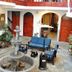 Hotel Choquequirao in Cusco courtyard with fountain, seating area, potted plants and wooden doors