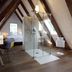 Dormero Hotel Schwäbisch Hall attic room with glass shower, desk, and bed