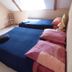 Au Pied Levé in Trévron bedroom with two twin beds, sloped ceiling, and a skylight