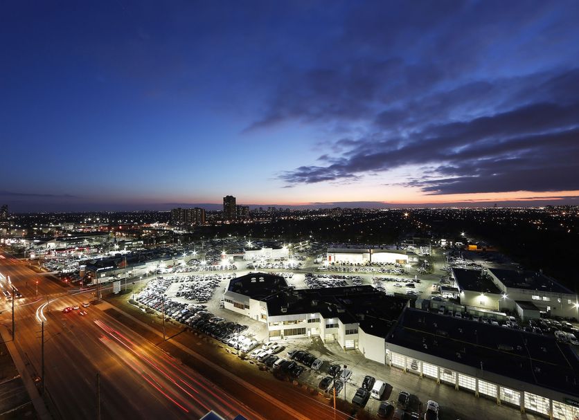 Liberty Suites in Richmond Hill with panoramic city lights at dusk and a busy road below