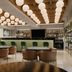 Hilton Garden Inn Mexico City Polanco lobby lounge with round tables, bar, and hanging globe lights