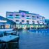 Apartamentos Sal Rossa in Sant Josep de sa Talaia with a poolside terrace and illuminated hotel exterior at dusk