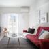 Central Cozy Apartments in Plaka by Upst living room with red sofa, TV, coffee table and balcony view in Athens