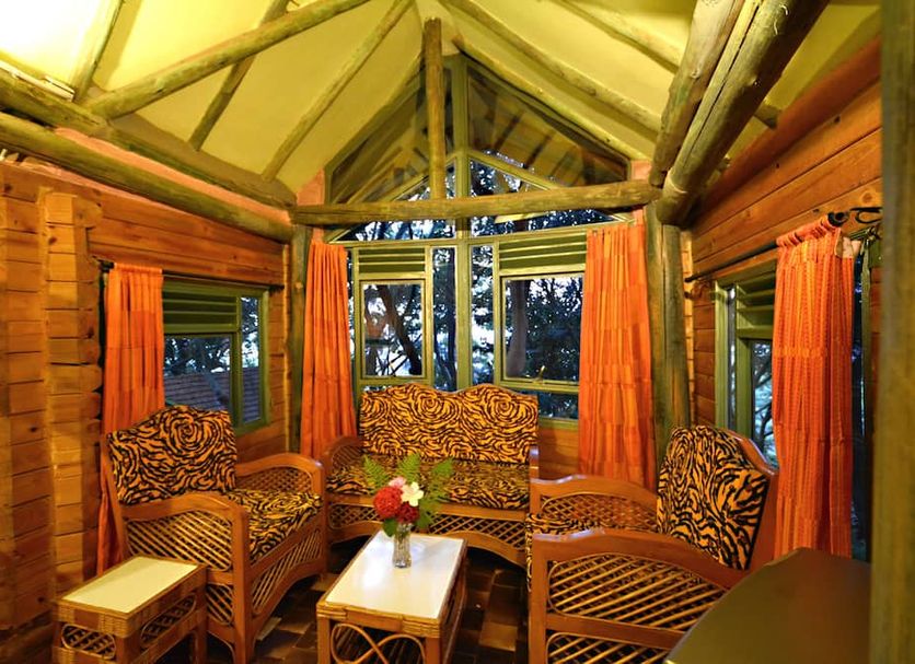Forest Cottages Kampala rustic cabin lounge with wicker seating and forest-view windows