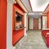 Hotel Del Sole in Pompei hallway with red sofa, orange walls, artwork and decorative columns