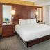 Residence Inn by Marriott Portsmouth guest room with king bed, wood headboard, and large window curtains