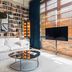 Stamba Hotel in Tbilisi suite with bookshelf wall, white sofa, round glass table and TV by window