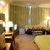 Guohao Hotel in Shijiazhuang guest room with bed, sofa, TV, and floor lamp