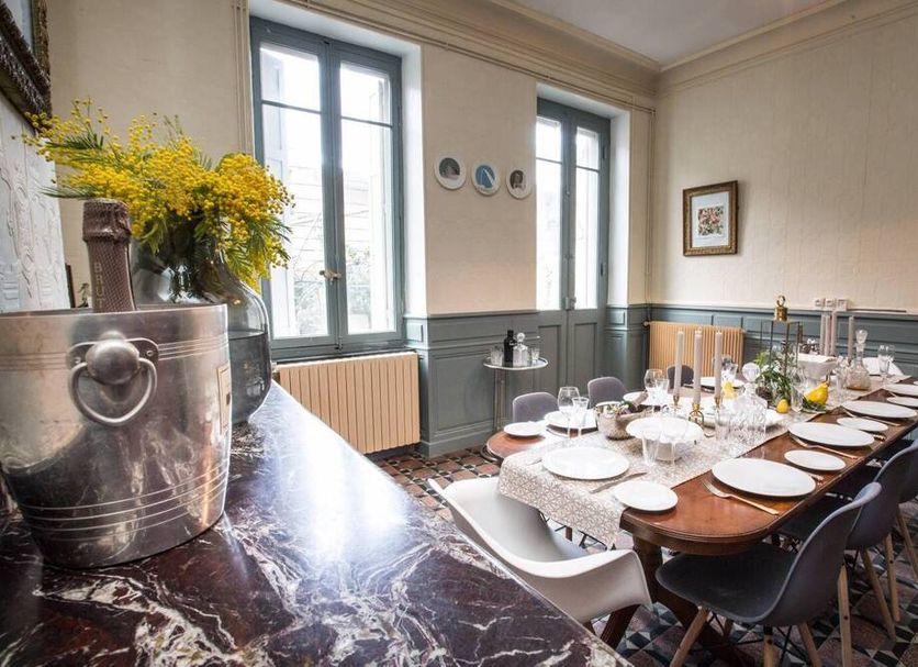 Carcassonne Townhouse dining room in Carcassonne with set table, tall windows, and floral arrangement