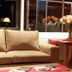 Rio Arriba Suites Apartments y Resto in Bella Vista lounge with beige sofa, flowers, and red chairs