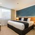Hotel Diana Woolloongabba in Brisbane guest room with king bed, lounge chair and large window