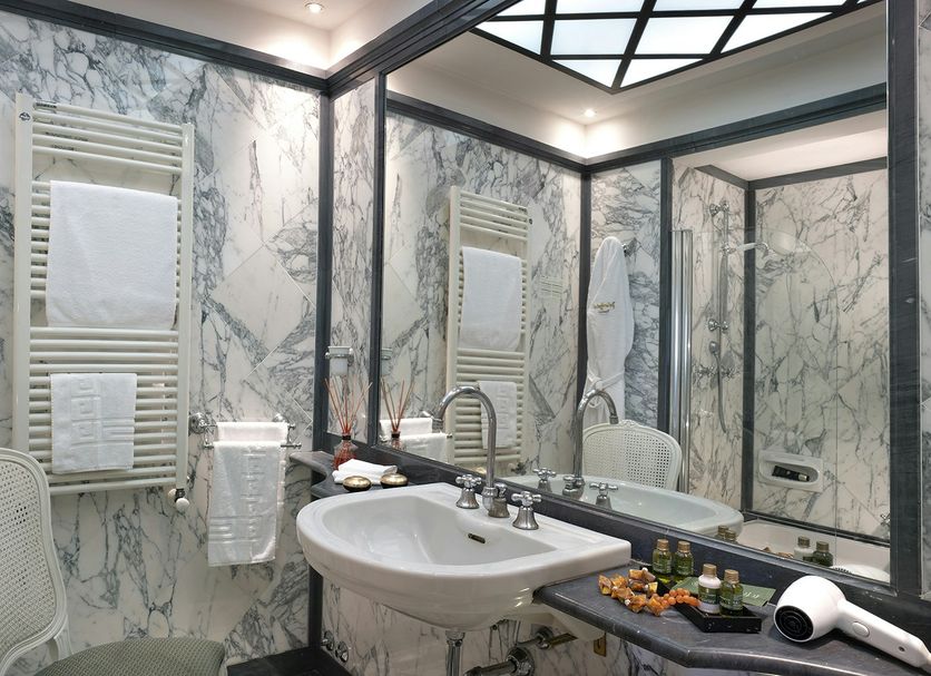 Palace Hotel Viareggio marble bathroom with sink, large mirror, towel warmers and shower area