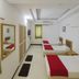Stayguru Usha Residency Bhuj triple room with three single beds and wall mirror
