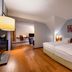 Mövenpick Hotel Egerkingen room with twin beds, hardwood floors and lounge seating in Egerkingen