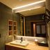 Suminoyu in Yamanouchi bathroom with vessel sink, large mirror, warm lighting, and wooden accents