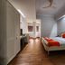 Park Palace Hotel Kolkata room with double bed, red accents, wood flooring and ceiling fan