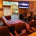 Lairds Lodge Inverness lounge with leather Chesterfield sofa, brick fireplace, wall TV and outdoor view