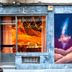 Supernova Hostel Porto facade with lit window, colorful mural, and street-level entrance