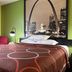 Super 8 by Wyndham Jacksonville guest room with bed, chair, lamp, and St. Louis skyline wall art
