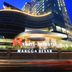 Swiss-Belhotel Mangga Besar in Jakarta, a high-rise hotel with illuminated curved façade at dusk