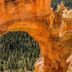 High Desert Inn in Salina overlooks a natural red rock arch framing a pine forest view.