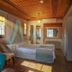 Panamare Apart Hotel Akyaka room with bed, teal sofa, wooden ceiling and sunlight in Akyaka