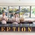 Reception desk at Grand Santhi Hotel in Denpasar with two staff standing behind the counter