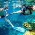 Blue Green Bay, Panormos: guests snorkeling in clear blue water above a coral reef