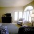 4 Seasons at Desert Breezes in Palm Desert guest room with bed, TV, chair, and bright windows