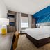 Comfort Inn & Suites Donna guest room with king bed, desk, and bright blue accent wall