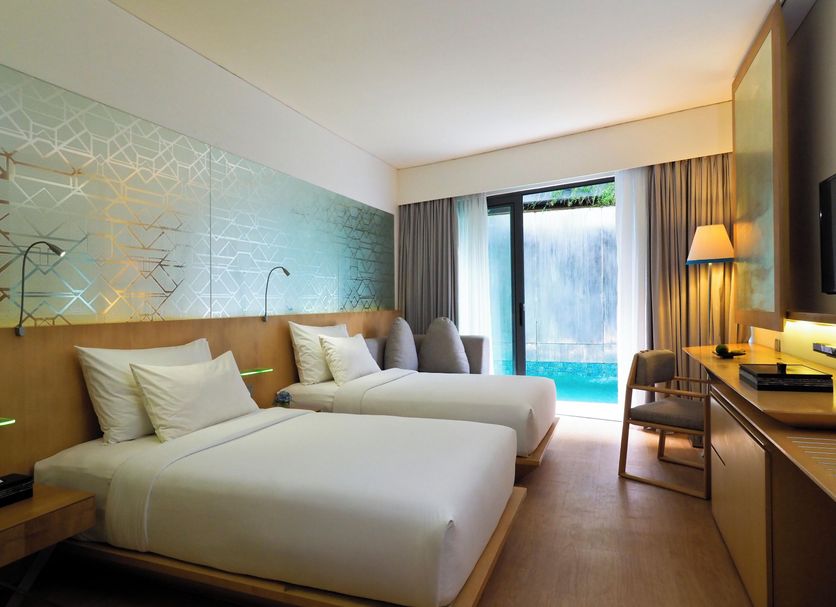 Ize Seminyak By Lifestyleretreats room with twin beds and sliding doors to a pool view in Kuta