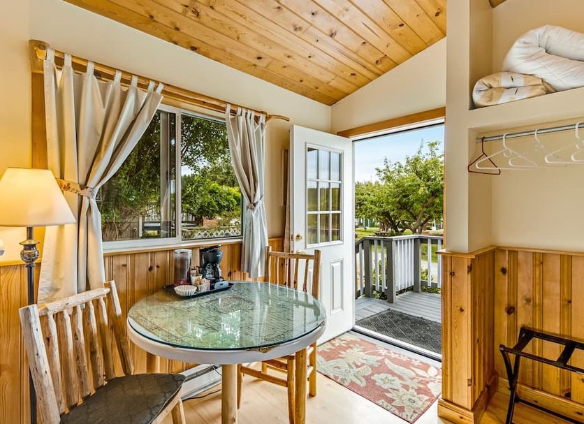 Deer Harbor Inn guest room with glass table, balcony door, and forest view in Deer Harbor