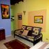 Arte Natura Boutique Hotel in La Fortuna: colorful room with sofa, wall art, and tiled floor
