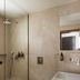 Dolphin Bay Seaside Resort & Suites bathroom in Galissas with glass shower, wall-mounted toilet and sink