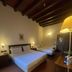 Bes Hotel Bergamo Cologno al Serio guest room with two beds, wood beams and warm lighting