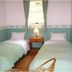 Pension Wave Inn in Itō twin room with two single beds, nightstand, and window