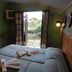 Pousada Atalaia room with twin beds and open French doors to a garden in Campos do Jordão